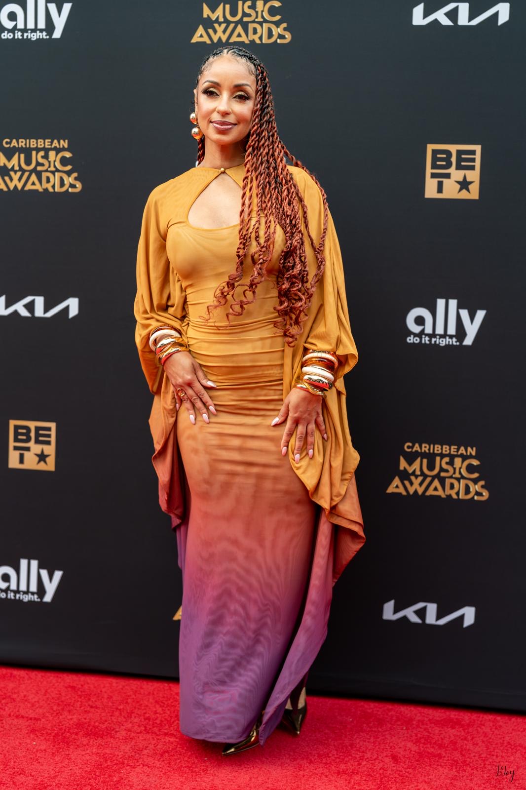 A guest in a gold and rose gown on the 2026 Caribbean Music Awards red carpet